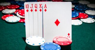 ABC Poker: Vor einem Hintergrund aus Pokerchips stehen die Karten 10, Bube, Dame, König und Ass in Karo auf einem grünen Pokertisch, davor liegen gestapelte Chips.